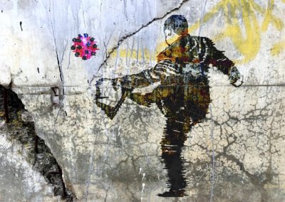 Graffiti background with man kicking a covid germ