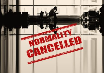 man sitting by himself in an airport with text that says Normality Cancelled